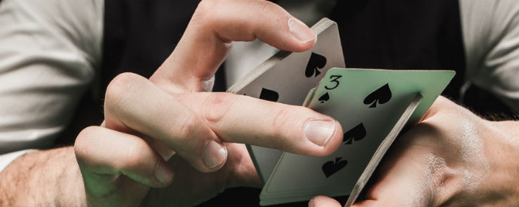 Blackjack Dealer holder et spil kort med tre af spar pa bunden