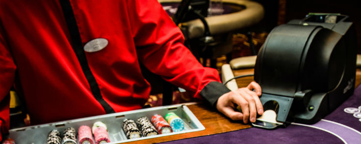 Blackjack Dealer med casino chips og kort shuffle maskine